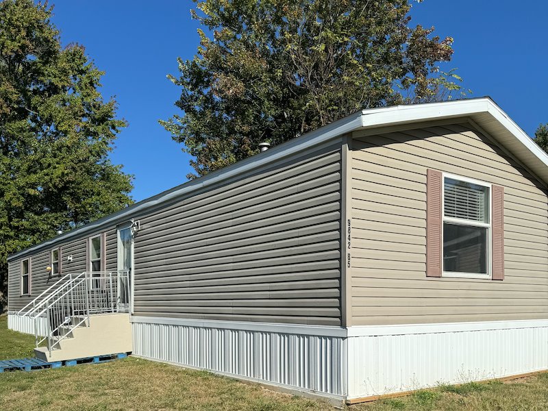 Light grey-tan singlewide manufactured home with steps